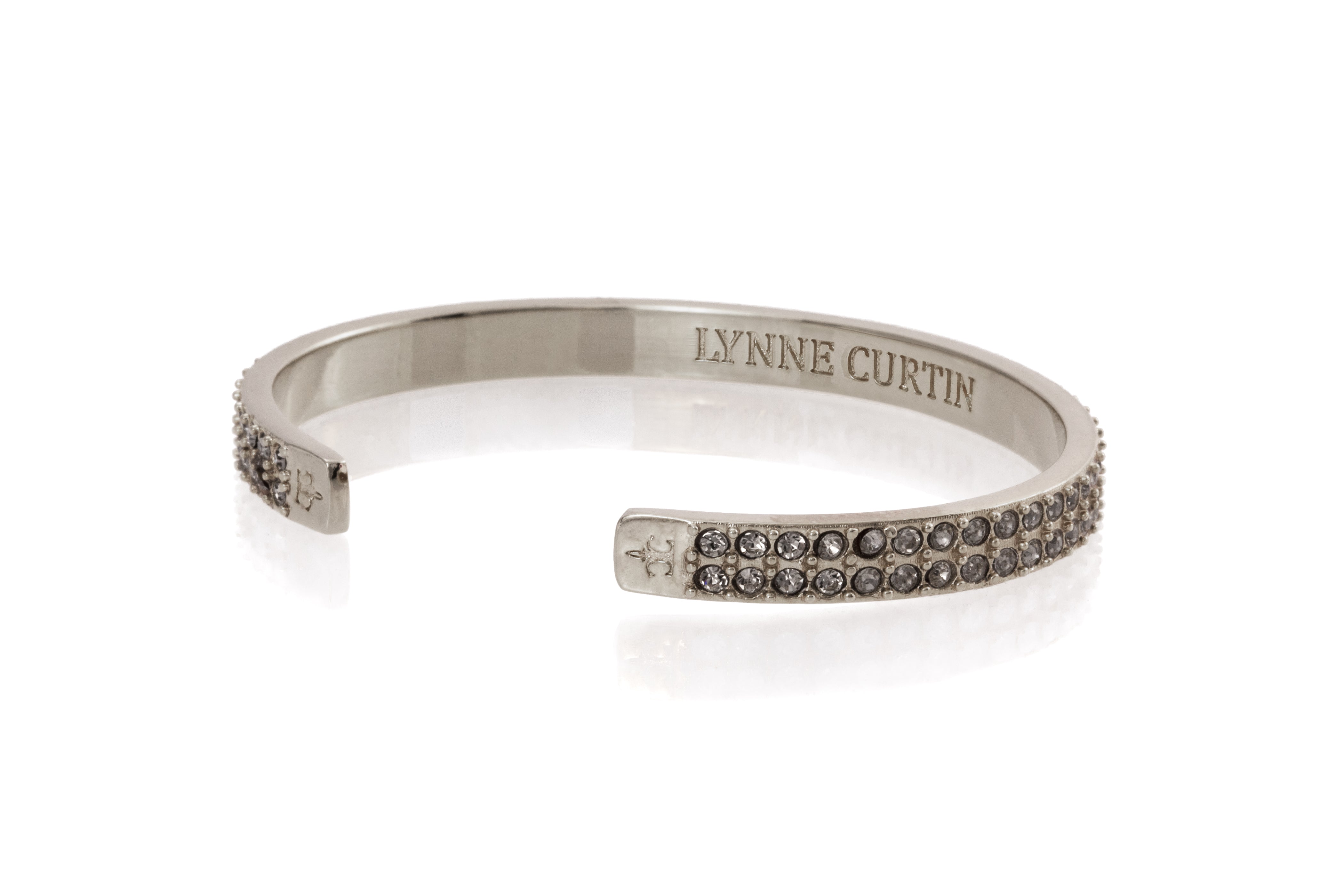 Pave  2 rows C.Z.in center of this beautiful 1/4" cuff bracelet signature logos on outside of each end .Silver plated